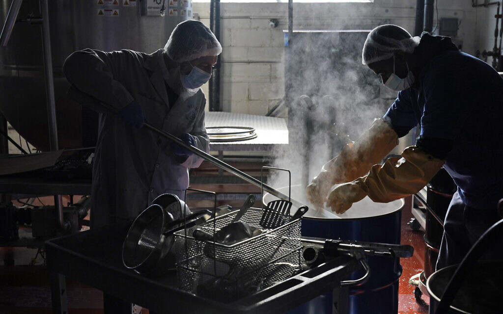 Rabbi Joseph Schwartz, left, and Ryan Eleazar use boiling water to kosherize equipment for the Hanan Products' kosher-for-Passover production run on Jan. 7, 2021.  (AP/Seth Wenig)