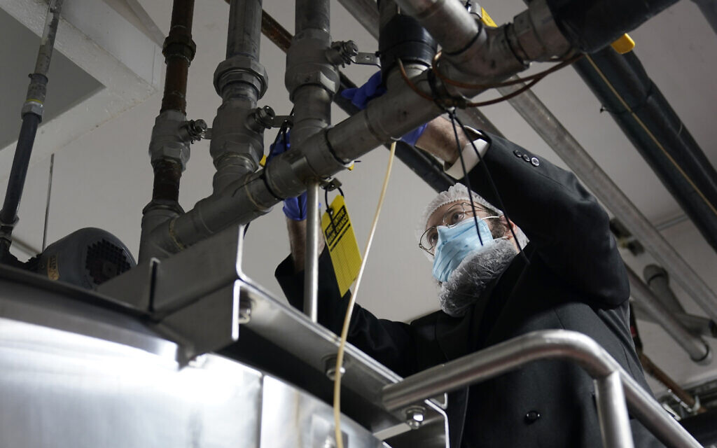 Rabbi Mendel Einhorn uses zip ties to prevent any contamination while helping Hanan Products prepare their factory for the kosher-for-Passover production run on Jan. 7, 2021, in Hicksville, N.Y. (AP/Seth Wenig)