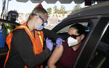 Vanessa Guerra (right), a special education teacher, receives a shot of the Moderna COVID-19 vaccine from nurse Kelly Mendoza, in Inglewood, California, March 2, 2021. (AP Photo/Marcio Jose Sanchez)