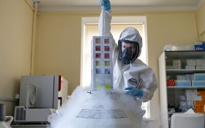 An employee works with a coronavirus vaccine at the Nikolai Gamaleya National Center of Epidemiology and Microbiology in Moscow, Russia, August 6, 2020. (Alexander Zemlianichenko Jr/Russian Direct Investment Fund via AP)