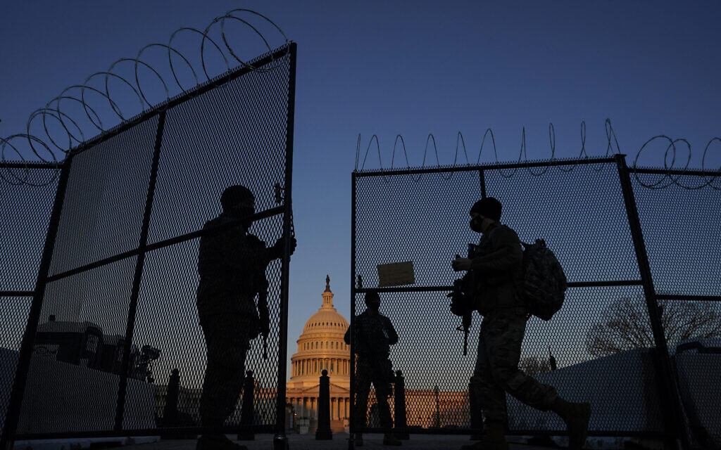 National Guard open a gate in the razor wire topped perimeter fence around the Capitol allow another member in at sunrise in Washington, March 8, 2021. (AP Photo/Carolyn Kaster) National Guard open a gate in the razor wire topped perimeter fence around the Capitol allow another member in at sunrise in Washington, March 8, 2021. (AP Photo/Carolyn Kaster)
