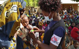 In this photo dated Friday Feb. 19, 2021, made available by Medecins Sans Frontieres, showing an MSF (Doctors Without Borders) staff member measuring a child's upper arm circumference to check for malnutrition in Meluco, in the northern Mozambican province of Cabo Delgado.  Northern Mozambique's humanitarian crisis is quickly growing with more than 650 000 people displaced by the Islamic extremist insurgency in Cabo Delgado province according to a statement Tuesday March 16, 2021, from International aid groups. (AP Photo/MSF)