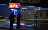 Law enforcement officials confer outside a massage parlor following a shooting on March 16, 2021, in Atlanta. (AP Photo/Brynn Anderson)