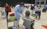 Medical staff administer the AstraZeneca vaccine at La Nuvola convention center in Rome, March 19, 2021. (AP Photo/Gregorio Borgia)