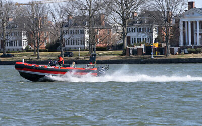 A District of Columbia Fire Boat checks buoys in the waterway next to Fort McNair, seen in background in Washington. March 19, 2021. (AP Photo/Jacquelyn Martin)
