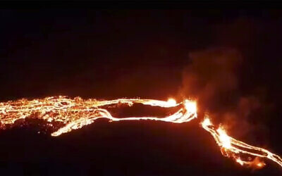 This photo provided by the Icelandic Met Office shows an eruption, center right, on the Reykjanes Peninsula in southwestern Iceland on Friday, March 19, 2021. The long dormant volcano flared to life Friday night, spilling lava down two sides in that area's first volcanic eruption in nearly 800 years. (Icelandic Met Office via AP)