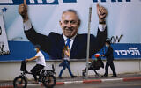 People pass an election campaign billboard for the Likud party that shows a portrait of its leader, Benjamin Netanyahu, in Ramat Gan, Israel, March 21, 2021. (AP Photo/Oded Balilty)
