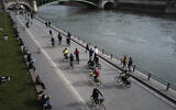 French police officers ride among Parisian bikers on the banks of the Seine river in Paris, March 21, 2021. (AP Photo/Francois Mori)