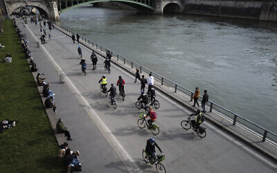 French police officers ride among Parisian bikers on the banks of the Seine river in Paris, March 21, 2021. (AP Photo/Francois Mori)