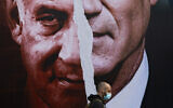 File: An election campaign billboard for the Blue and White party depicting Benny Gantz and Benjamin Netanyahu hangs on a street in Tel Aviv, March 11, 2021. (AP Photo/ Oded Balilty)