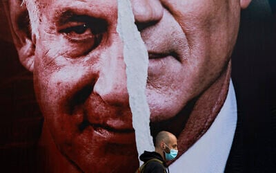 File: An election campaign billboard for the Blue and White party depicting Benny Gantz and Benjamin Netanyahu hangs on a street in Tel Aviv, March 11, 2021. (AP Photo/ Oded Balilty)