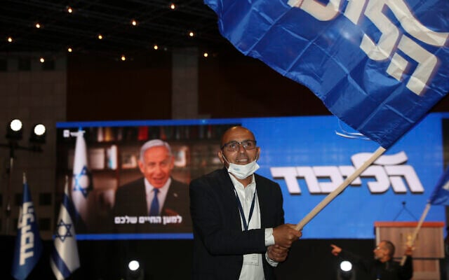 Prime Minister Benjamin Netanyahu's supporters wave Likud party flags after first exit poll results for the Israeli elections at his party's headquarters in Jerusalem, Tuesday, March. 23, 2021. (AP Photo/Ariel Schalit) Prime Minister Benjamin Netanyahu's supporters wave Likud party flags after first exit poll results for the Israeli elections at his party's headquarters in Jerusalem, Tuesday, March. 23, 2021. (AP Photo/Ariel Schalit)