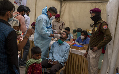 A health worker takes a nasal swab sample of a passenger to test for coronavirus at a bus terminal in New Delhi, India, Wednesday, March 24, 2021. (AP Photo/Altaf Qadri) A health worker takes a nasal swab sample of a passenger to test for coronavirus at a bus terminal in New Delhi, India, Wednesday, March 24, 2021. (AP Photo/Altaf Qadri)