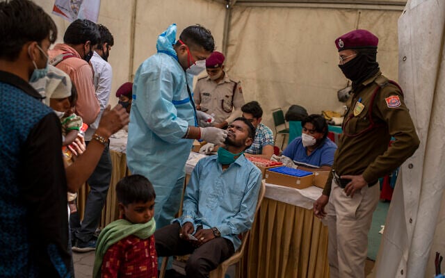 A health worker takes a nasal swab sample of a passenger to test for coronavirus at a bus terminal in New Delhi, India, Wednesday, March 24, 2021. (AP Photo/Altaf Qadri) A health worker takes a nasal swab sample of a passenger to test for coronavirus at a bus terminal in New Delhi, India, Wednesday, March 24, 2021. (AP Photo/Altaf Qadri)