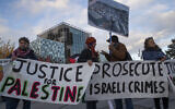 Demonstrators carry banners outside the International Criminal Court, ICC, rear, urging the court to prosecute Israel's army for alleged war crimes, The Hague on November 29, 2019. (AP/Peter Dejong)