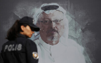 In this October 2, 2019, photo, a Turkish police officer walks past a picture of slain Saudi journalist Jamal Khashoggi near the Saudi Arabia consulate in Istanbul. (AP Photo/Lefteris Pitarakis, File)