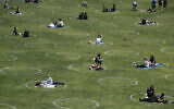Visitors set up inside circles designed to help prevent the spread of the coronavirus by encouraging social distancing, at Dolores Park in San Francisco, June 28, 2020. (AP Photo/Jeff Chiu)