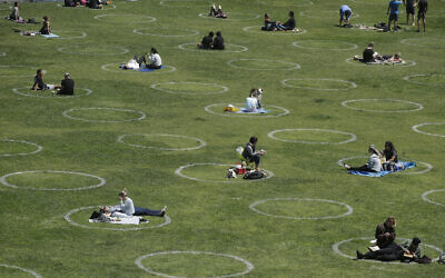Visitors set up inside circles designed to help prevent the spread of the coronavirus by encouraging social distancing, at Dolores Park in San Francisco, June 28, 2020. (AP Photo/Jeff Chiu)