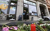 Flowers and candles lie in memory of the victim of a right-wing shooting attack in 2019 in front of the kebab shop where killing took place, in Halle, Germany, October 9, 2020. (Hendrik Schmidt/dpa via AP)