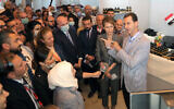 In this photo provided by the official Facebook page of the Syrian Presidency, Syrian President Bashar Assad, right, and first lady Asma Assad, center right, speak during a visit to the Producers exhibition, in Damascus, Syria, Nov. 4, 2020 (Syrian Presidency Facebook page via AP)