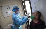 Illustrative: A medical worker of the National Health Organisation (EODY) conducts a rapid test for the coronavirus in Athens, Greece, on February 2, 2021. (AP Photo/Petros Giannakouris)