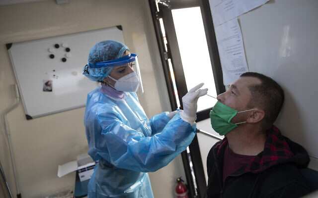 Illustrative: A medical worker of the National Health Organisation (EODY) conducts a rapid test for the coronavirus in Athens, Greece, on February 2, 2021. (AP Photo/Petros Giannakouris) Illustrative: A medical worker of the National Health Organisation (EODY) conducts a rapid test for the coronavirus in Athens, Greece, on February 2, 2021. (AP Photo/Petros Giannakouris)