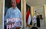 Father Nazeer Dako arranges a Vatican flag to welcome Pope Francis at St. Joseph's Chaldean Church ahead of the Pope's visit, in Baghdad, Iraq, March 2, 2021. (Khalid Mohammed/AP)