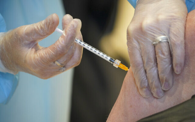 A health worker administers a dose of the AstraZeneca vaccine against COVID-19 to a patient inside the convention center known as "La Nuvola", The Cloud, in Rome, Wednesday, March 10, 2021. (AP/Andrew Medichini)