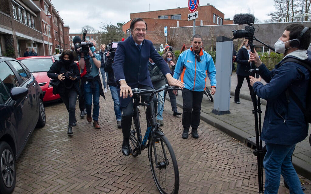Dutch caretaker Prime Minster Mark Rutte leaves on his bicycle after casting his vote in a general election in The Hague, Wednesday, March 17, 2021. (AP Photo/Peter Dejong)