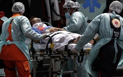 Healthcare workers take on a stretcher a patient suspected of having COVID-19 from an ambulance, at the HRAN public hospital in Brasilia, Brazil, March 23, 2021 (AP Photo/Eraldo Peres)
