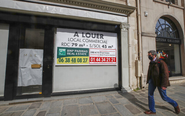 A man wearing a mask to prevent the spread of the coronavirus walks past a vacant boutique for rent in Paris, March 25, 2021 (AP Photo/Michel Euler) A man wearing a mask to prevent the spread of the coronavirus walks past a vacant boutique for rent in Paris, March 25, 2021 (AP Photo/Michel Euler)