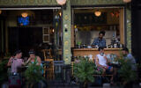Israelis wear protective facemasks as they sit in a cafe in Tel Aviv, July 8, 2020. (Miriam Alster/FLASH90)