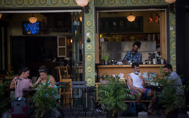 Israelis wear protective facemasks as they sit in a cafe in Tel Aviv, July 8, 2020. (Miriam Alster/FLASH90) Israelis wear protective facemasks as they sit in a cafe in Tel Aviv, July 8, 2020. (Miriam Alster/FLASH90)
