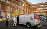 Magen David Adom workers wear protective clothing outside the coronavirus unit at Hadassah Ein Karem hospital in Jerusalem, on October 19, 2020. (Olivier Fitoussi/Flash90)