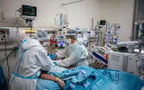 Ilustrative: Hadassah Ein Kerem staff members work in the hospital's coronavirus ward, in Jerusalem on February 1, 2021 (Olivier Fitoussi/Flash90)