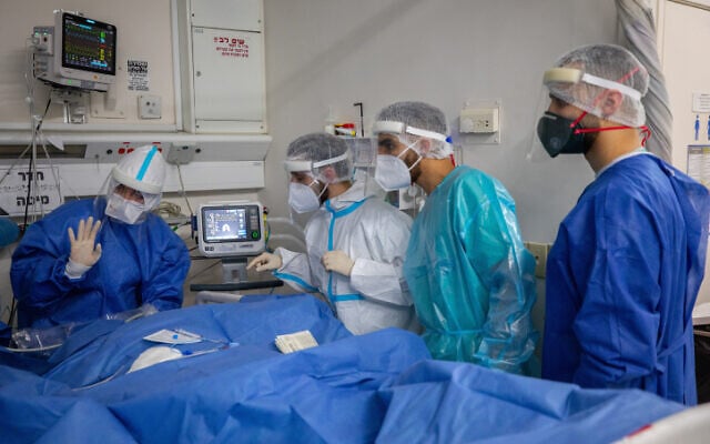 Hadassah Ein Kerem Hospital team members wearing safety gear as they work in a coronavirus ward, on February 01, 2021. (Olivier Fitoussi/Flash90) Hadassah Ein Kerem Hospital team members wearing safety gear as they work in a coronavirus ward, on February 01, 2021. (Olivier Fitoussi/Flash90)