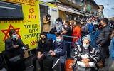 People receive COVID-19 vaccine injections in a mobile Magen David station at the Mahane Yehuda market in Jerusalem on February 22, 2021. (Olivier Fitoussi/Flash90)