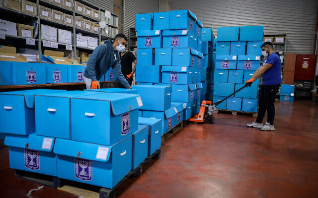 Workers at the Central Elections Committee warehouse in Modiin, ahead of the upcoming elections. February 23, 2021. (Flash90) Workers at the Central Elections Committee warehouse in Modiin, ahead of the upcoming elections. February 23, 2021. (Flash90)