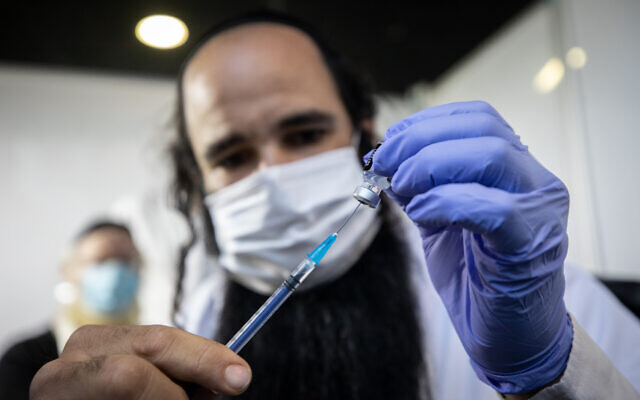 Illustrative: A medical worker prepares a COVID-19 vaccine at a Clalit vaccination center in Jerusalem on February 25, 2021. (Olivier Fitoussi/Flash90) Illustrative: A medical worker prepares a COVID-19 vaccine at a Clalit vaccination center in Jerusalem on February 25, 2021. (Olivier Fitoussi/Flash90)