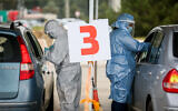 Illustrative -- Healthcare workers take test samples in a drive-thru complex at the Golani Interchange, March 4, 2021 (David Cohen/Flash90)