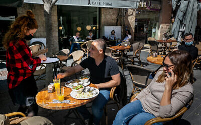 Customers sit at a cafe  in Jerusalem on March 7, 2021. (Olivier Fitoussi/Flash90)