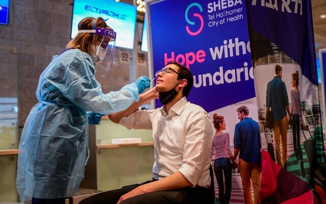 Medical technicians test passengers for COVID-19 at the Ben Gurion International Airport near Tel Aviv on March 8, 2021. (Avshalom Sassoni/Flash90) Medical technicians test passengers for COVID-19 at the Ben Gurion International Airport near Tel Aviv on March 8, 2021. (Avshalom Sassoni/Flash90)