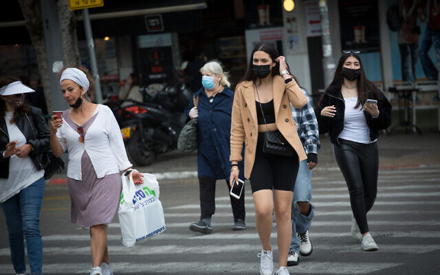 Israelis wear protective face masks as they walk in Tel Aviv on March 11, 2021. (Miriam Alster/FLASH90) Israelis wear protective face masks as they walk in Tel Aviv on March 11, 2021. (Miriam Alster/FLASH90)