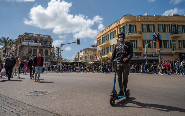 Israelis wear protective face masks in Tel Aviv, on March 12, 2021. (Yahav Gamliel/Flash90)