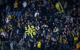 Soccer fans cheer during a match between Beitar Jerusalem FC and Ashdod FC at Teddy Kollek stadium in Jerusalem, on March 17, 2021. (Flash90)