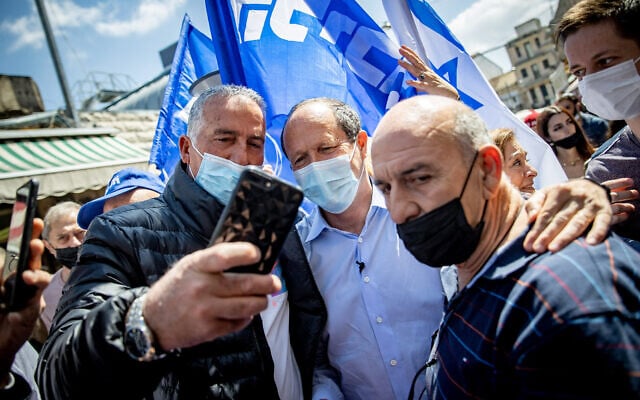 Likud MK Nir Barkat takes a selfie with supporters during a campaign stop at Jerusalem's Mahane Yehuda on March 19, 2021. (Yonatan Sindel/Flash90) Likud MK Nir Barkat takes a selfie with supporters during a campaign stop at Jerusalem's Mahane Yehuda on March 19, 2021. (Yonatan Sindel/Flash90)