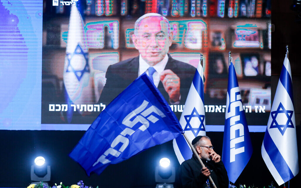 A Likud supporter in front of a video of Benjamin Netanyahu at a party event in Jerusalem on March 23, 2021. (Olivier Fitoussi/Flash90)