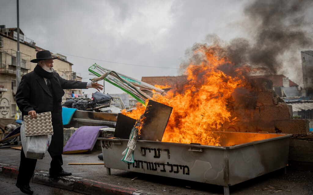 Ultra-Orthodox Jews burn leavened items in a final preparation before the Passover holiday in the Mea Shearim neighborhood of Jerusalem, March 26, 2021 (Yonatan Sindel/Flash90)
