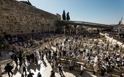 Jewish worshipers cover themselves with prayer shawls as they pray in front of the Western Wall, during the priestly blessing event of the Passover holiday, March 29, 2021. (Olivier Fitoussi/Flash90)
