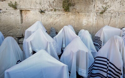 File: Jewish worshippers cover themselves with prayer shawls as they pray in front of the Western Wall, during the priestly blessing event of the Passover holiday, March 29, 2021. (Olivier Fitoussi/Flash90)